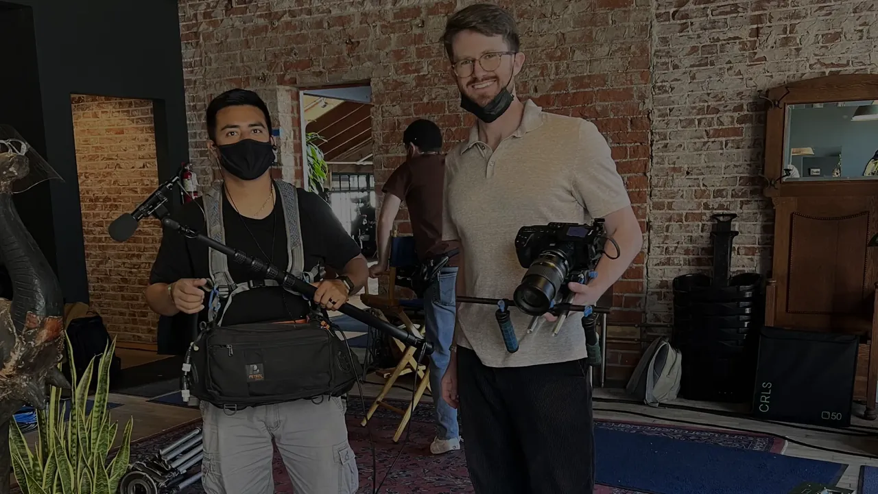 Two crew members holding Blackmagic 6K rigs on set