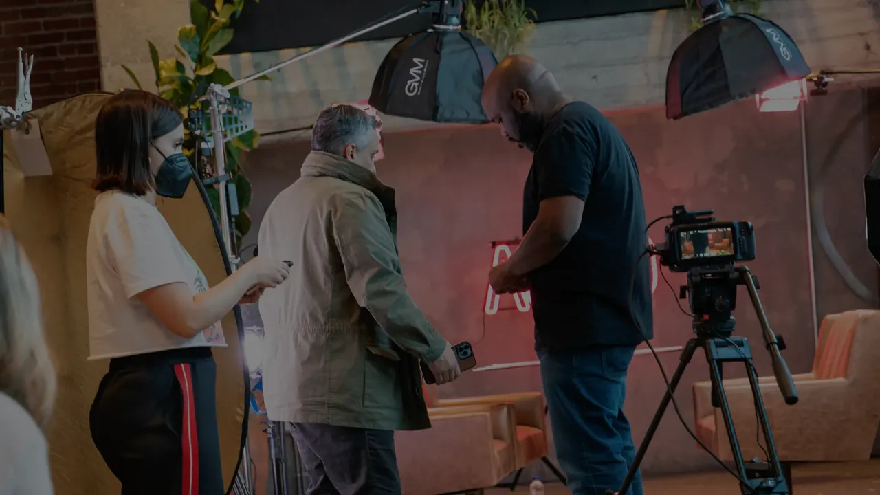 Crew setting up a camera on a neon-lit set